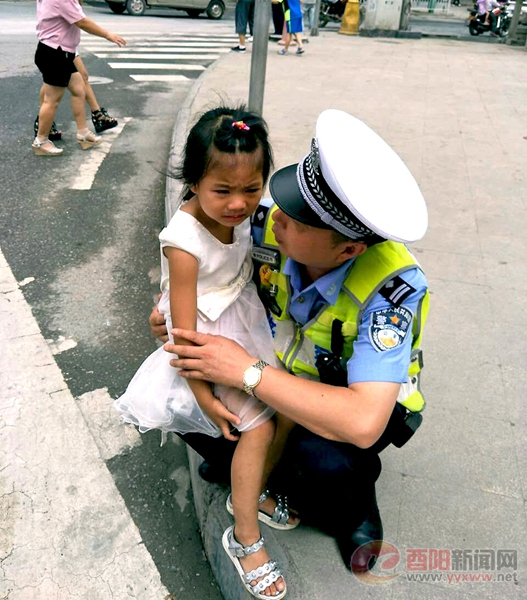 图为民警在安慰迷路的小女孩.