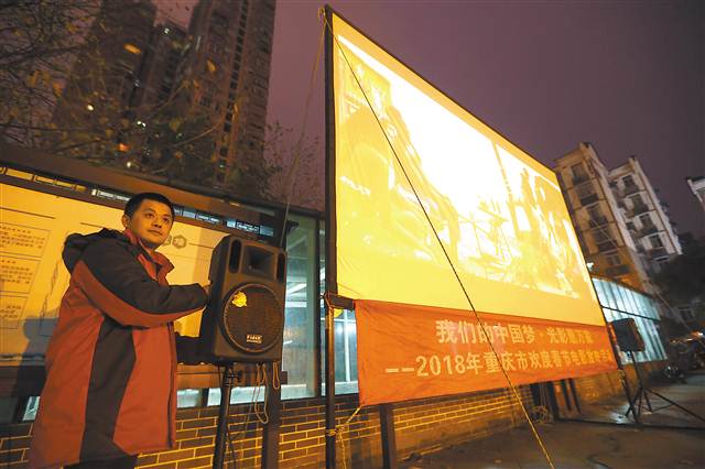 2月20日,南岸区花园路街道南湖社区广场,王丛啸在为居民放露天电影.