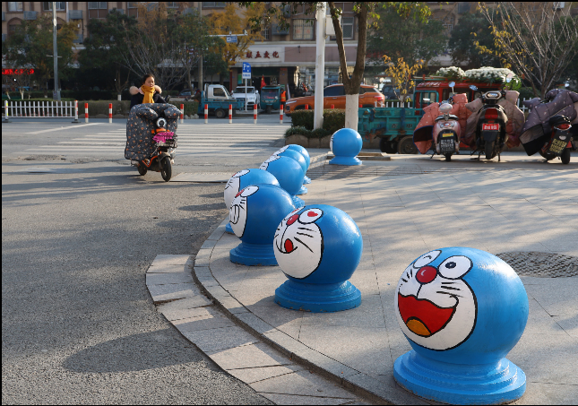 重庆:隔离墩石头上画脸谱 成为一道亮丽风景线