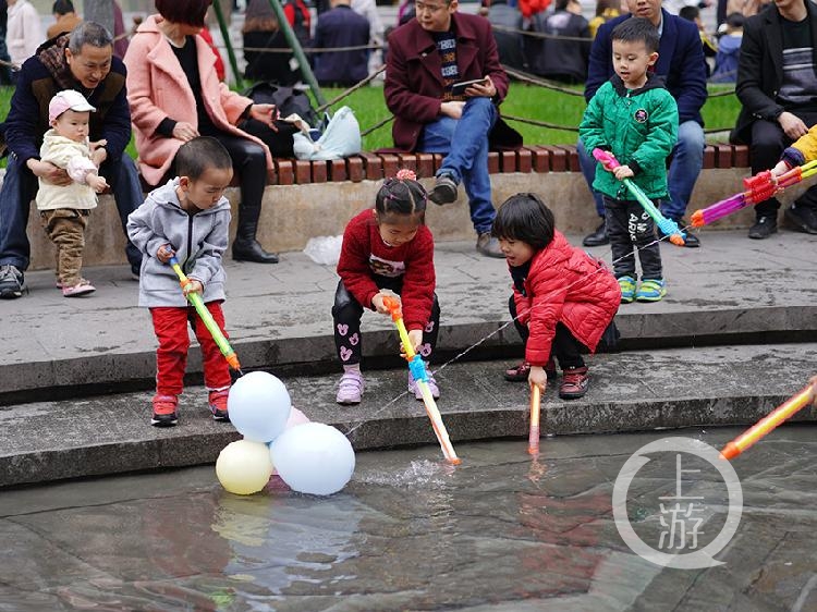 小孩子们正在用水枪喷气球.