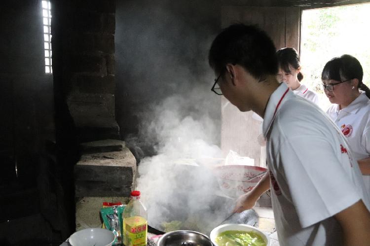 （志愿者在为老人做饭  重庆理工大学供图 华龙网发）.jpg