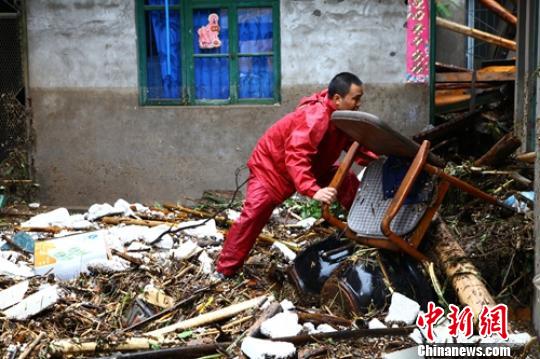 洪水过后民众清理废墟。　钟欣 摄